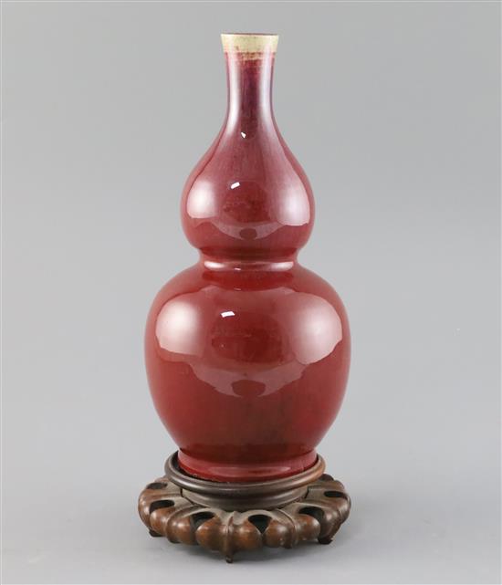 A Chinese sang de boeuf double gourd vase, 19th century H. 25cm, wood stand